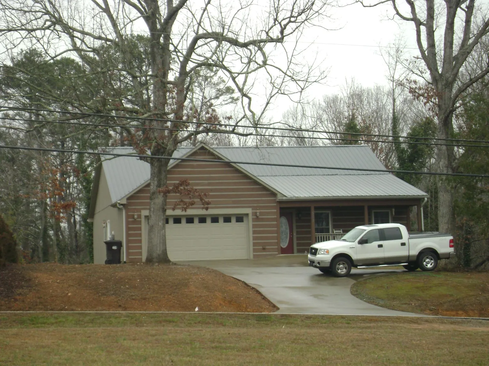 Gray metal roof on a log sided house with an attached two car garage in Monrovia